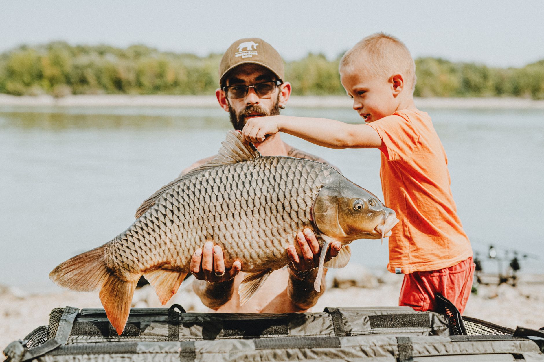 Melf und ein junger Angler mit großem Karpfen am See